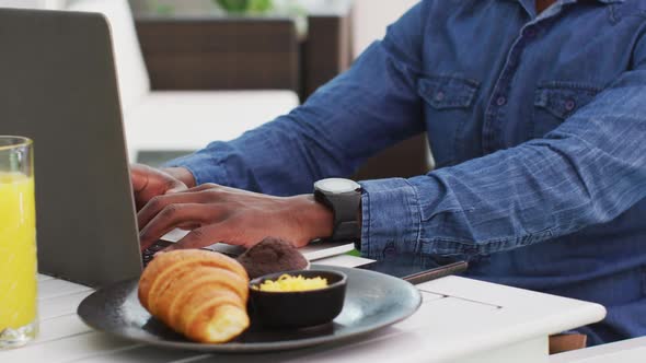 African american businessman using laptop in cafe