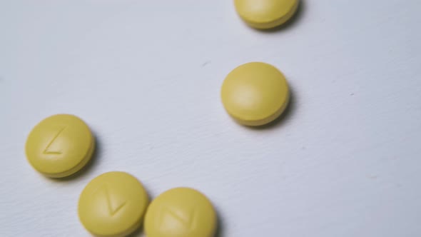 Yellow Pills with Marks Lies on Light Background Macro