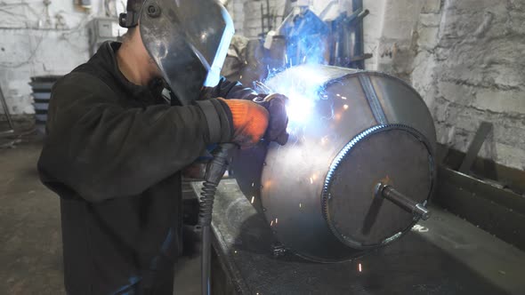 Worker in Protective Mask Welding Metal Construction