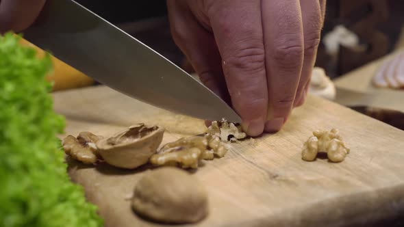 Close Up Video: Chef Cuts Walnuts on the Wooden Board, Cooking Salad, Vitamin Vegetarian Food