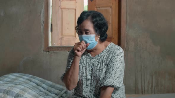 Sick Asian Senior Woman Wearing Mask With Sore Throat And Having Cough In Country Home