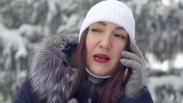 Young Woman Talking on the Phone in a Winter Park