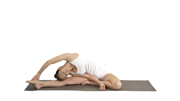 Beautiful young woman wearing white clothing doing yoga