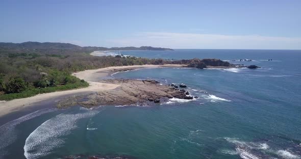 Aerial drone view of the beach, rocks and tide pools in Playa Palada, Guiones, Nosara, Costa Rica