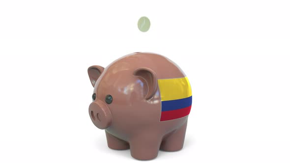 Putting Money Into Piggy Bank with Flag of Colombia