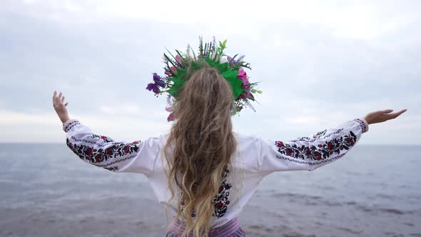 Back View Slim Young Woman in Embroidered Ukrainian Dress Raising Hands in Slow Motion Admiring