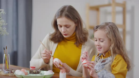 Woman and Girl Painting on Easter Eggs