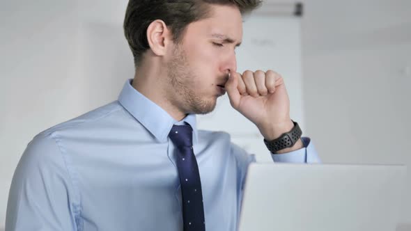 Close Up of Young Businessman Coughing at Work