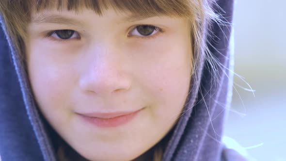 Portrait of happy child girl in warm clothes in autumn outdoors.