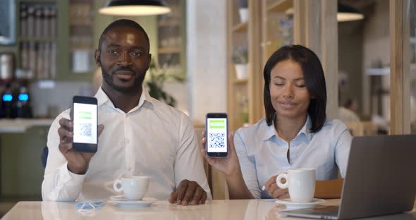 Portrait of Business Colleagues in Restaurant Showing Vaccinated Qrcode on Smartphone at Camera