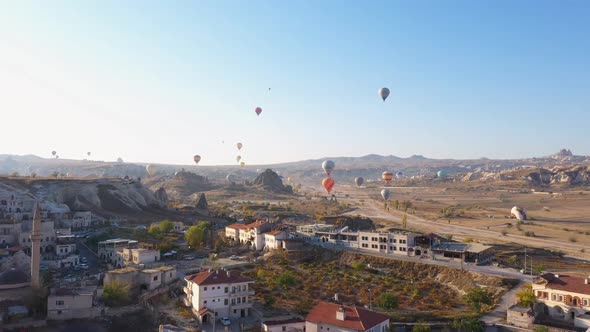 Hot Air Balloons Flying Over Goreme Village at Cappadocia, Turkey.