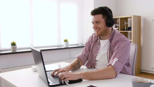 Happy Man in Headphones with Laptop at Office 49