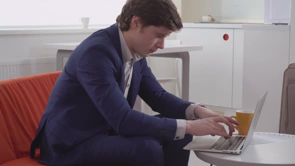 Young Male Typing on Laptop in Flat