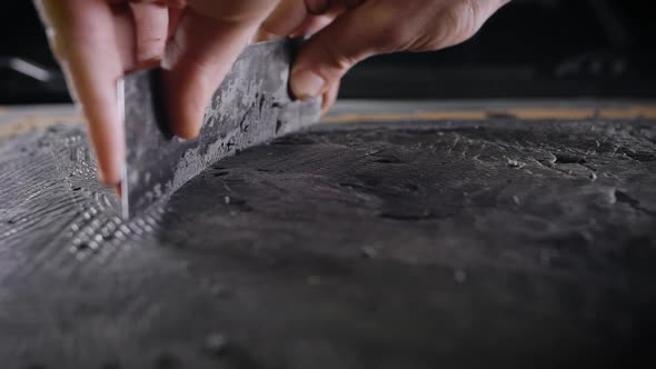 A Close-up of a Man's Hand with a Tool. A Professional Removes the Form From the Clay with the Help