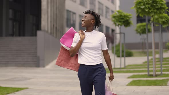 Young Happy Smiling Fashionable African American Woman Holding Paper Shopping Bags