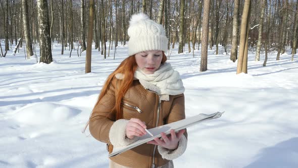 Red-Haired Teen Child Staying At Winter Park And Paints On Paper