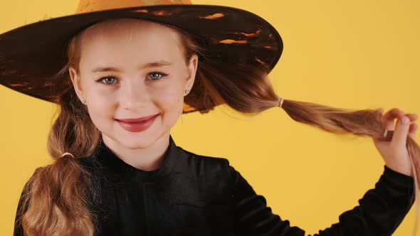Little Blonde Girl in Witch Costume on Halloween at Orange Studio Background