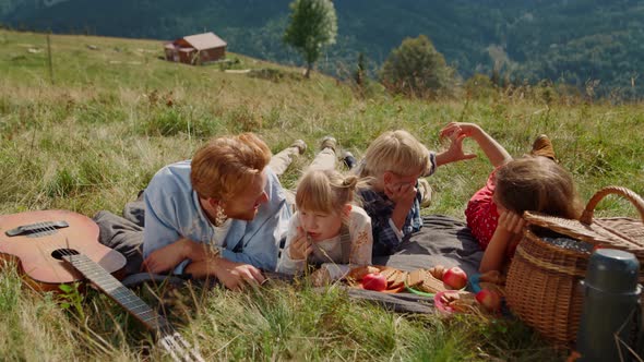 Parents Enjoy Picnic Children Lying Grass Mountain Slope