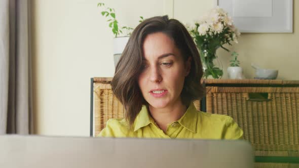 Midsection of caucasian woman on laptop video call working from home