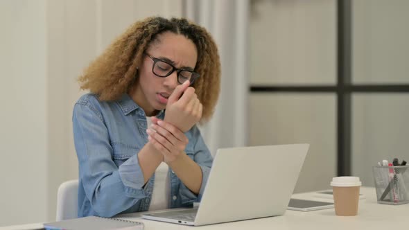 African Woman Having Wrist Pain While Typing on Laptop