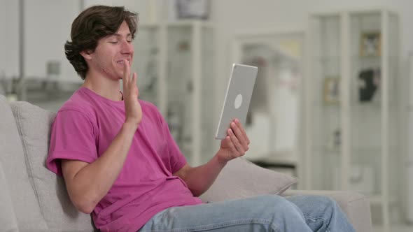 Cheerful Casual Young Man Doing Video Chat on Tablet 