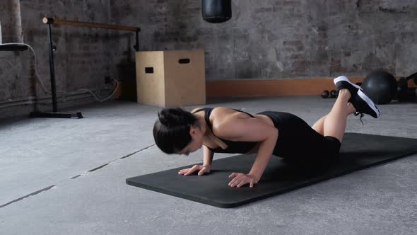 Young Indian Athletic Woman Doing Push-up Exercise, Kneeling, Dressed in Sportswear Black 