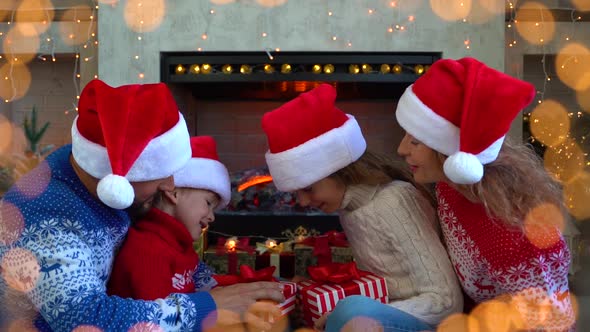 Happy family opening gift box in Christmastime