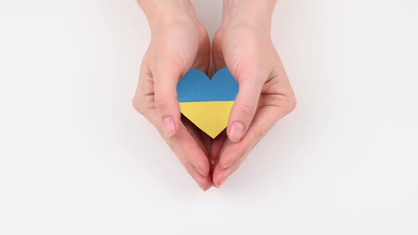 Woman Opens Her Palms with a Heart with the Flag of Ukraine