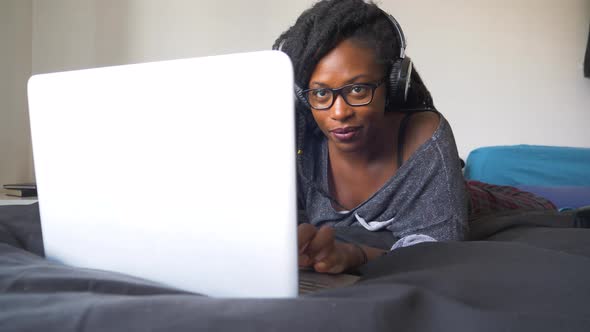 Slow motion shot of young woman using laptop at home