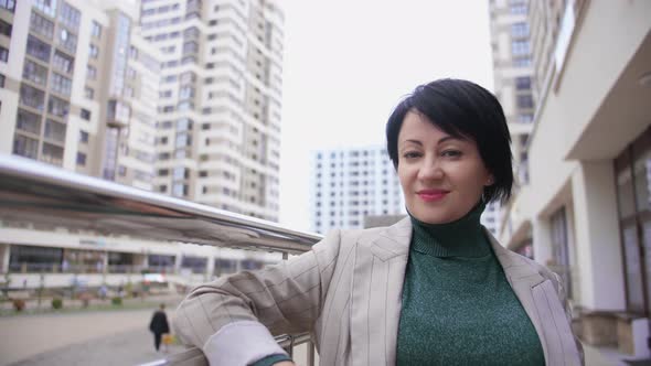 Portrait of a Woman in the City Looking at the Camera and Smiling in the Evening