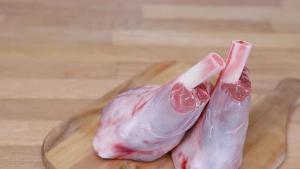 Two Lamb Shanks on Wooden Cutting Board. - Top Down Shot