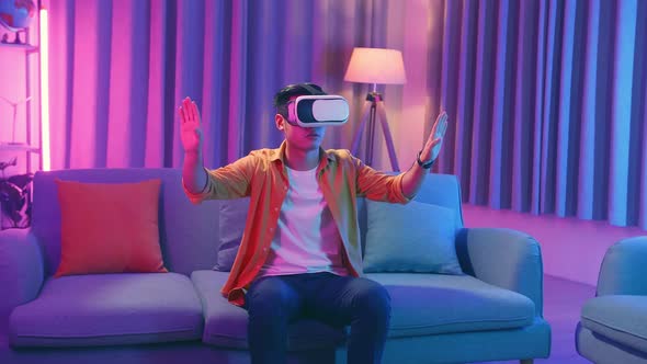 Young Asian Man Wearing Vr Headset At Living Room, Using Hand Touching And Slide