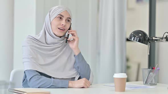 Young Arab Woman Talking on Smartphone in Office