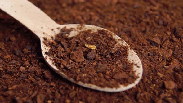 Roasted chicory root powder in wooden teaspoon. Brown instant herbal granules. Macro