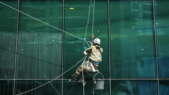 Window Cleaner at Work Washing Office Building Glass Facade