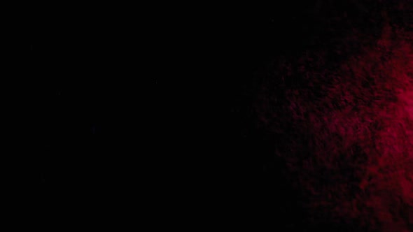 Red and Blue Water Spray Mixed on a Black Background. Slow Motion alt