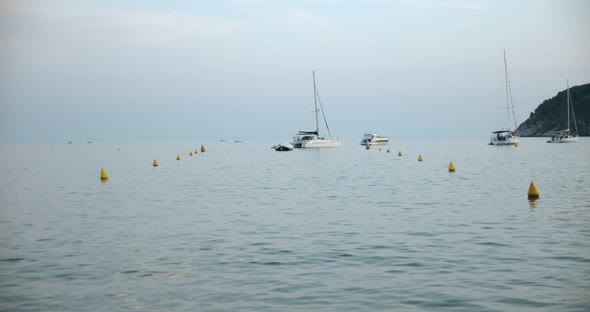 Calm Surface of Water Bay with Buoys and Sailboat