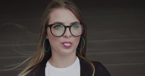 Stylish Teenager in Glasses Inflates Bubble of Chewing Gum and Has Fun
