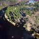Aerial view of the river between the pines. Flying over a winding riverbed surrounded by treetops - VideoHive Item for Sale