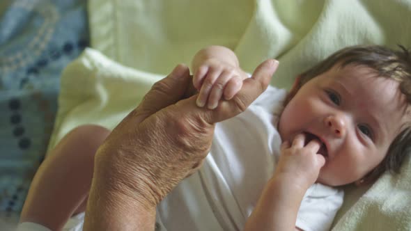 Beautiful Slow Motion of Baby Smiling and Holding Grandfather's Finger