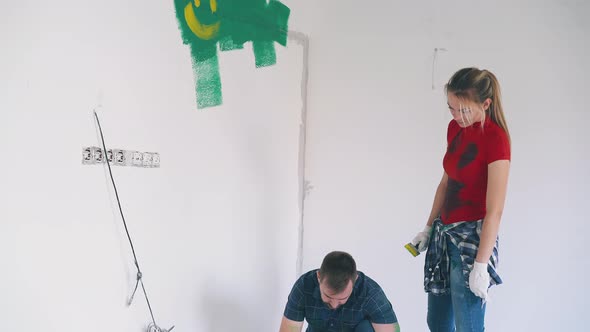 Girl with Paint Strokes Stands Near Boyfriend in Empty Room