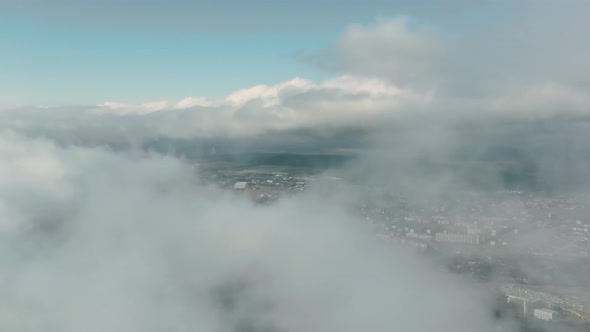 Aerial View of the Suburbs in the Mountains Through Low Cloud Cover