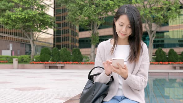 Woman working on mobile phone at outdoor