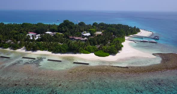 Natural fly over tourism shot of a white paradise beach and turquoise sea background in vibrant 4K