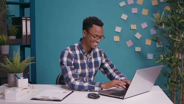 African American Man Listening to Gossip and Rumor at Laptop