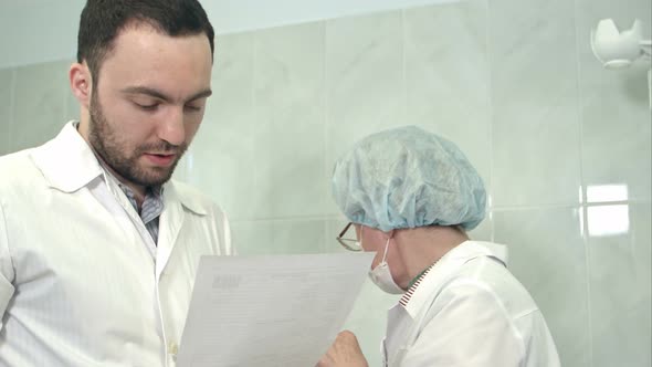 Male Doctor and Nurse Discussing Blood Sample