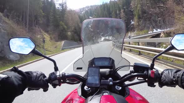 Motorcyclist Rides on Beautiful Landscape Mountain Road Near Snowy Switzerland Alps