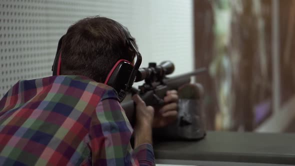 Close Up of a Man Shooting Use Rifle at Shooting Range in Headphones