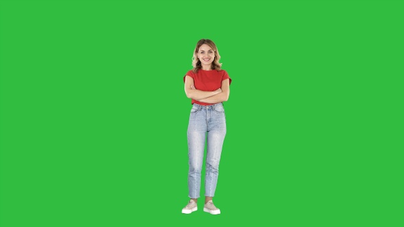 Smiling young woman with her arms folded on a Green Screen