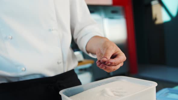 Close-up: The chef takes the salt and puts it into the pot